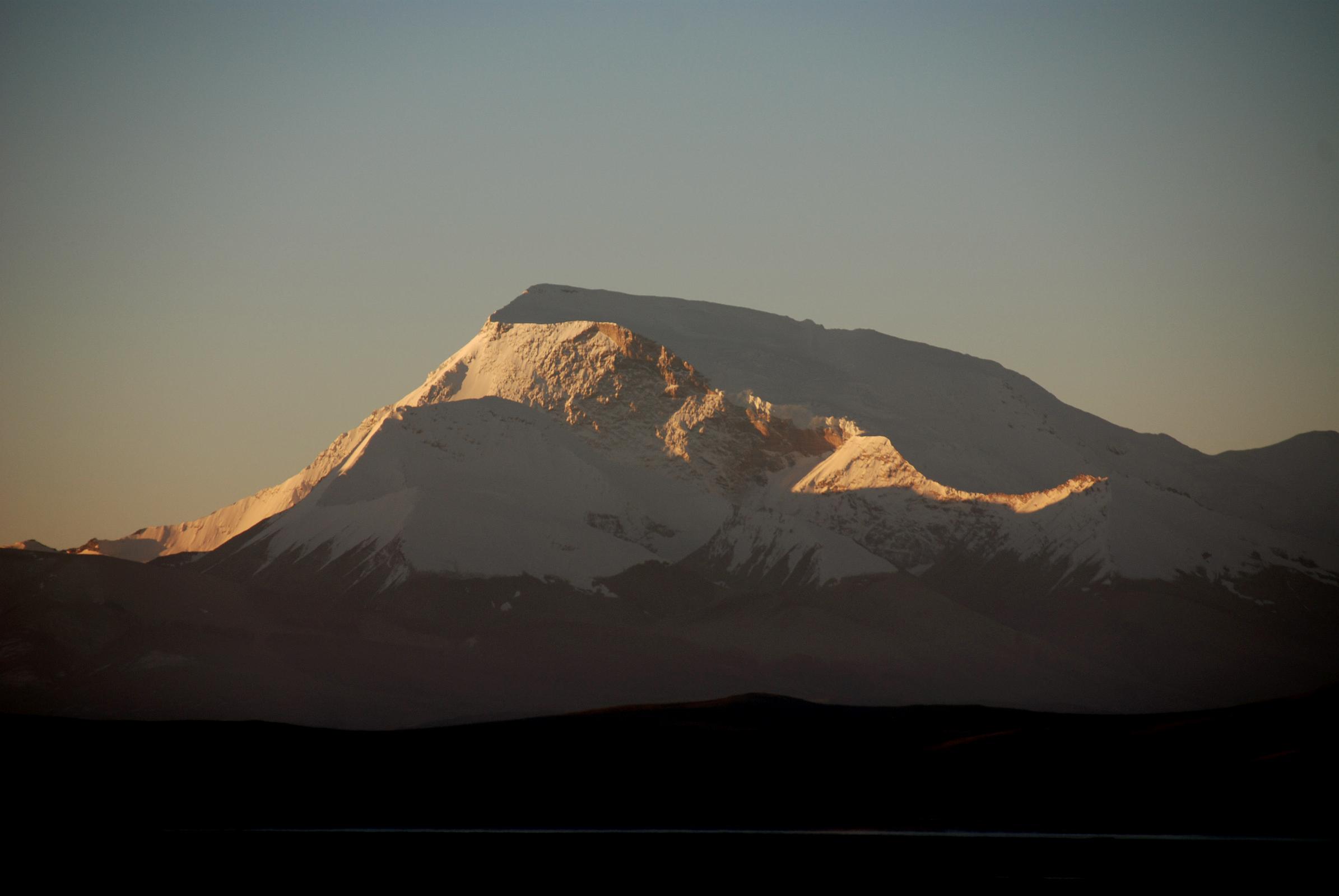 01 Gurla Mandhata Sunrise From Darchen At Beginning Of Kailash Outer Kora Gurla Mandhata (7728m) shines in the first light of sunrise seen from Darchen. Gurla Mandhata was first climbed by a Chinese-Japanese Expedition under climbing leader Katsutoshi Hirabayashi with eight climbers reaching the top on May 26, 1987 and another five climbers reaching the summit the next day.